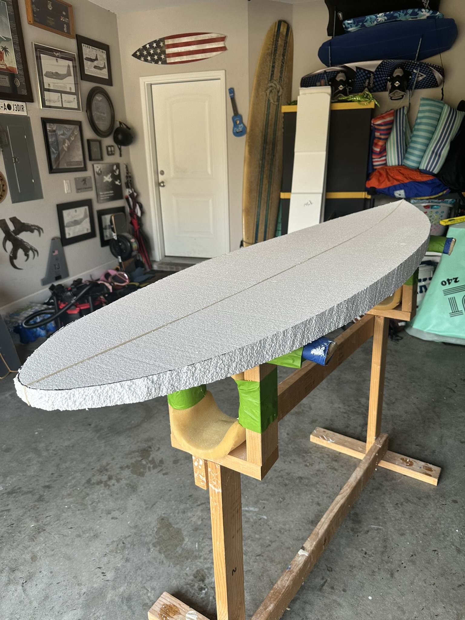 A foam blank on a homemade shaping stand in the Nav City Surf garage